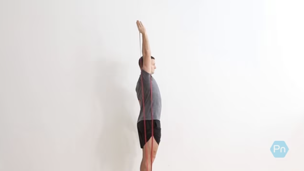 Athlete performing an overhead band press with locked core