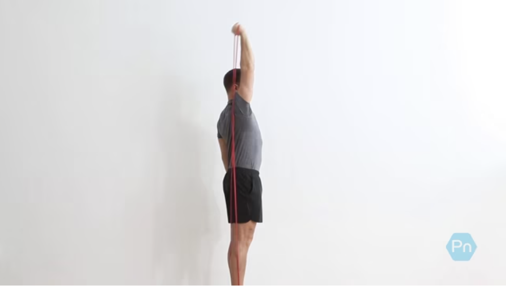Athlete performing overhead band extension with proper elbow tuck