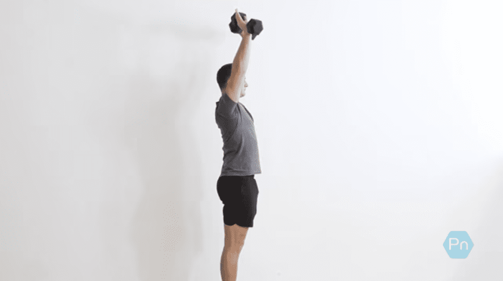 Athlete performing dumbbell overhead shrugs with locked elbows