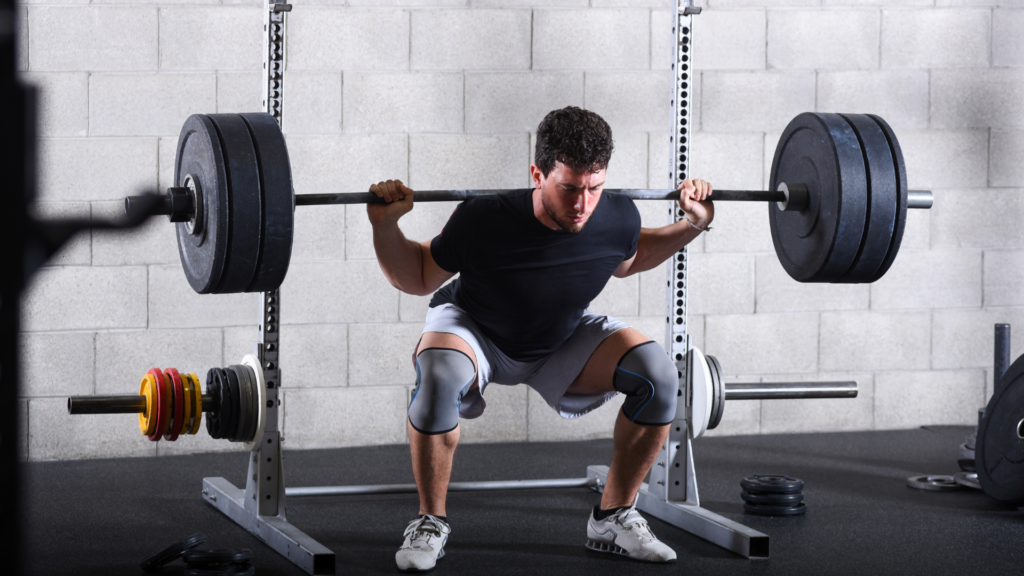 Strong man performing a heavy squat exercise with focused determination and proper form.
