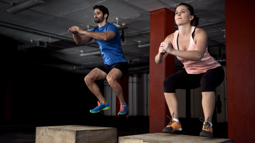 A man and a woman doing box jumps