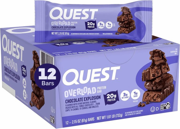 Purple box of 12 Quest Overload Chocolate Explosion protein bars with one wrapped bar resting on top, displaying labels for 20g of protein, 3g of net carbs, and 1g of sugar, verifying its macro profile for the review.