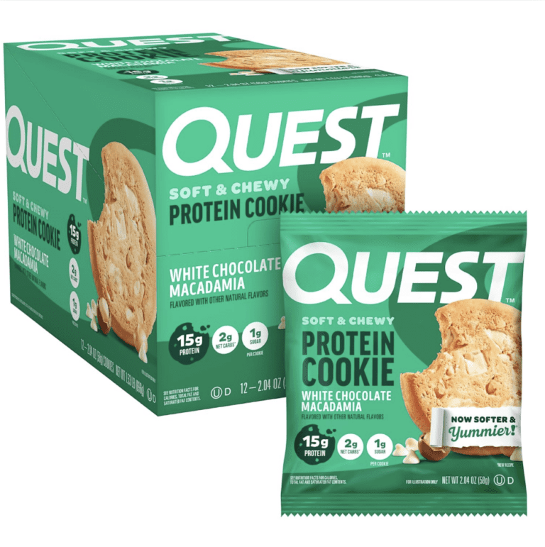 Green box and single wrapper of Quest Soft & Chewy Protein Cookies in White Chocolate Macadamia flavor, displaying labels for 15g of protein, 2g of net carbs, and 1g of sugar, verifying its low-carb macro profile for the review.